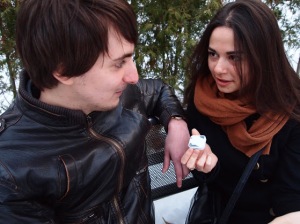 Photo of a man and a woman having a conversation using a small device.